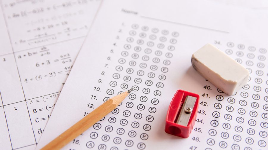 Pencil, Sharpener and eraser on answer sheets or Standardized test form with answers bubbled. multiple choice answer sheet