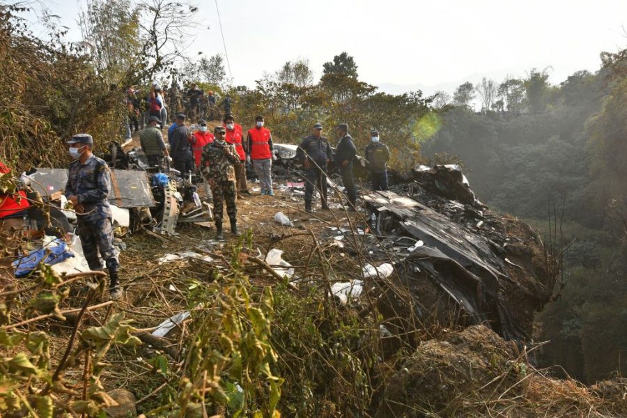 Rescuers gather at the site of a plane crash in Pokhara on January 15, 2023. - At least 67 people were confirmed dead on January 15 when a plane with 72 on board crashed in Nepal, police said, in the Himalayan countrys deadliest aviation disaster in three decades. (Photo by PRAKASH MATHEMA / AFP) (Photo by PRAKASH MATHEMA/AFP via Getty Images)