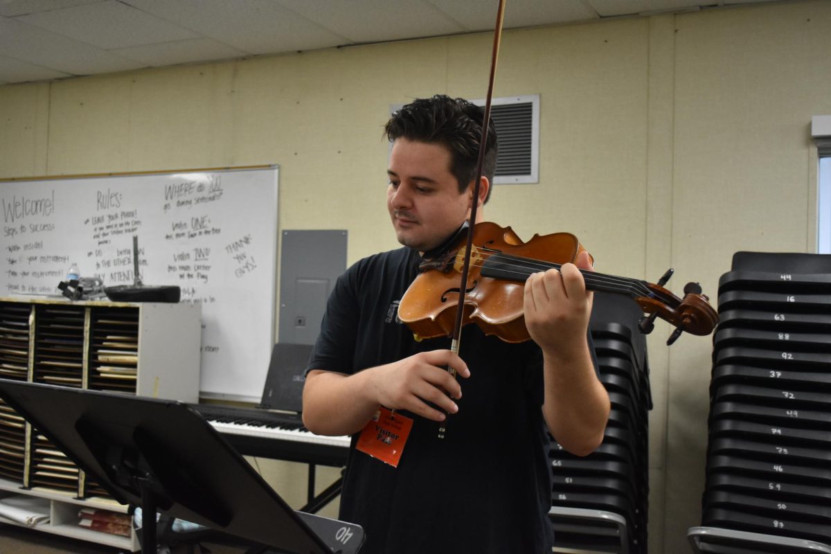 Mr. Canada plays the violin for his class.