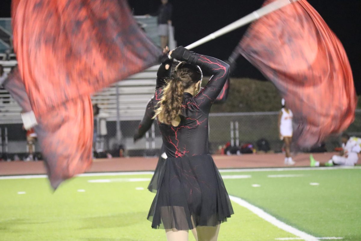 Colorguard performing during a halftime football game.
