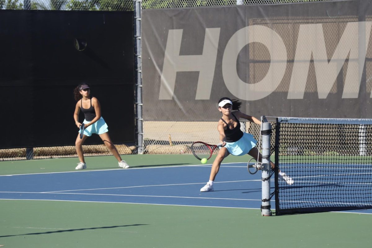 Eva Ebrahim (11) and Mica Malek (12) playing doubles.