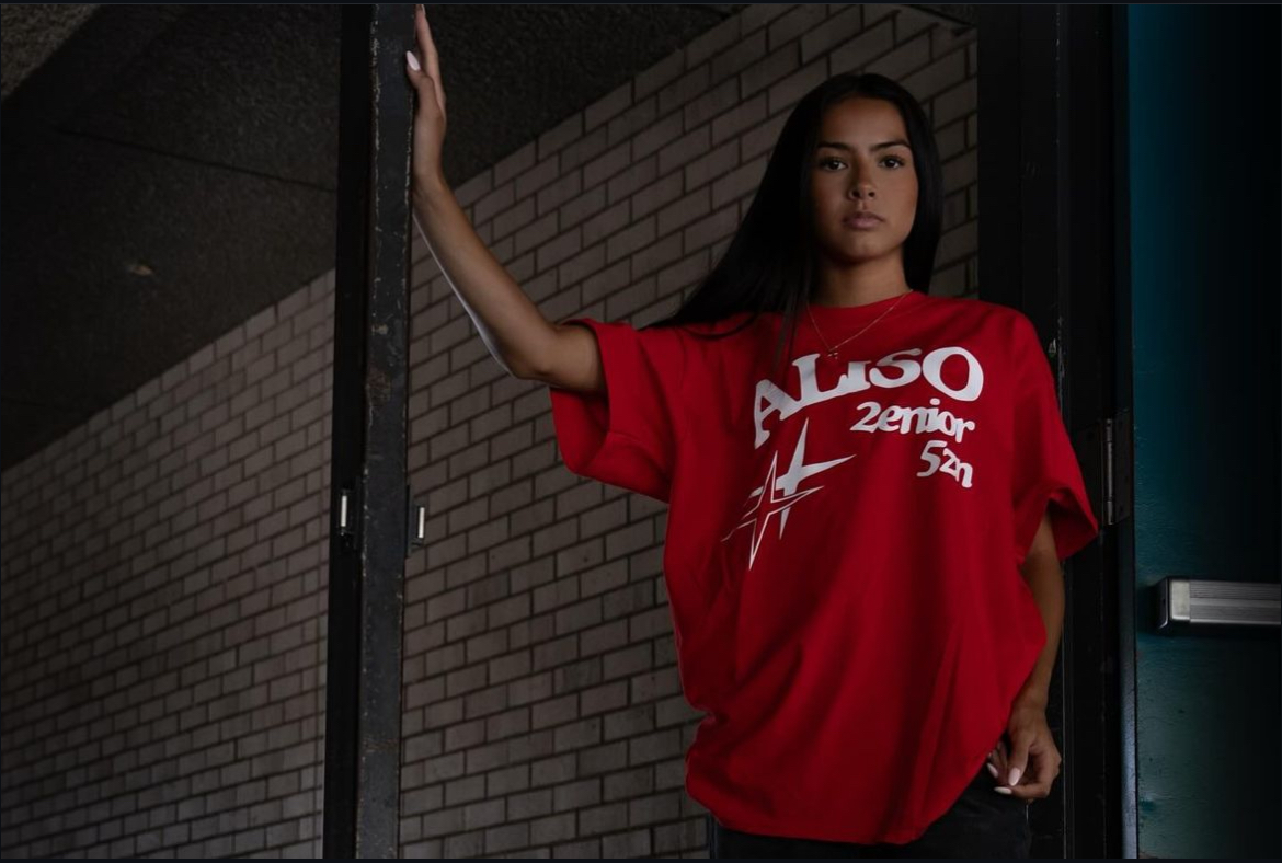 Christina Zeke poses with the new Senior Merch
Photo taken from @anhswolverines on Instagram
