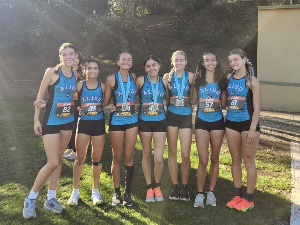 Girls Cross Country pose for a photo after a win
